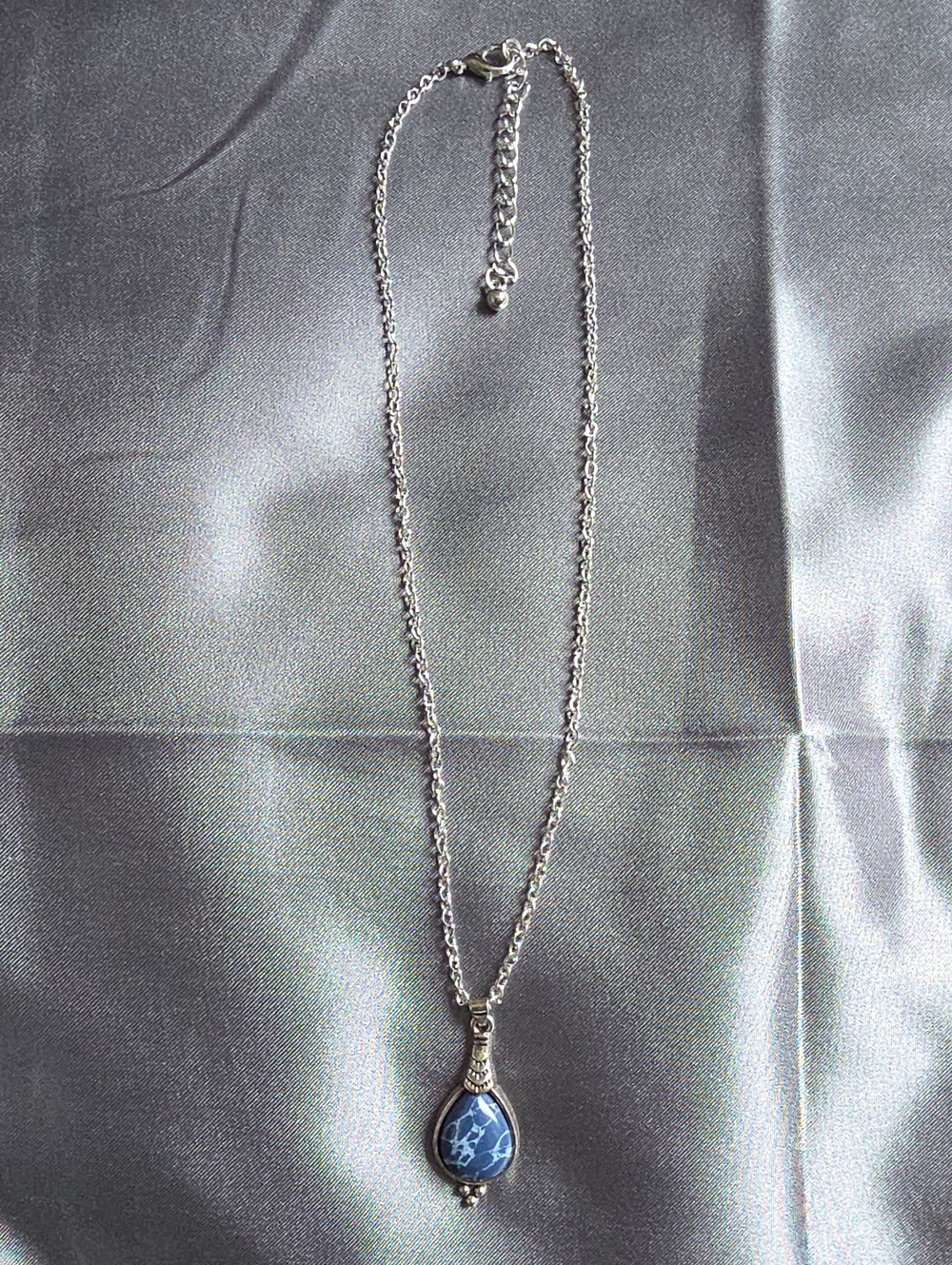 Bohemian-style teardrop pendant necklace features a blue Stone Silvertone
